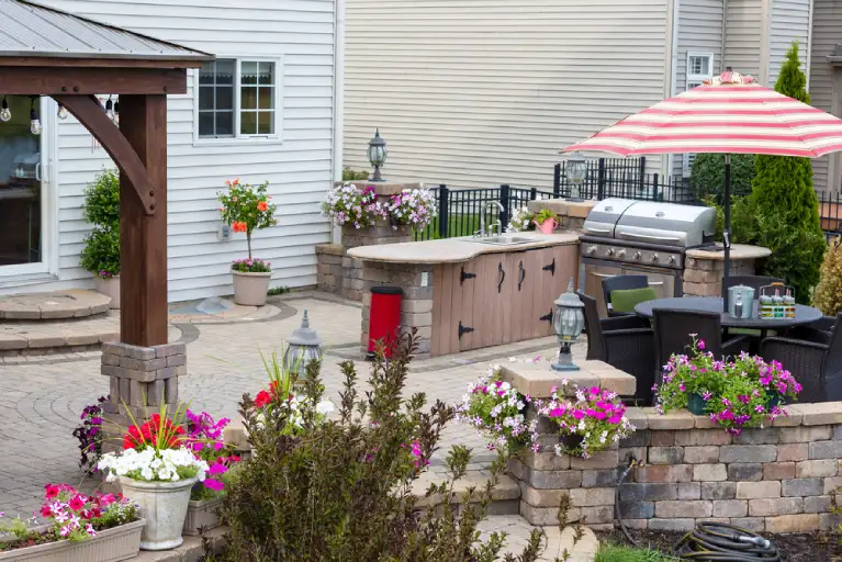 Outdoor kitchen-ready patio with slip-resistant pavers in a tropical backyard setting in Huntington Beach, California