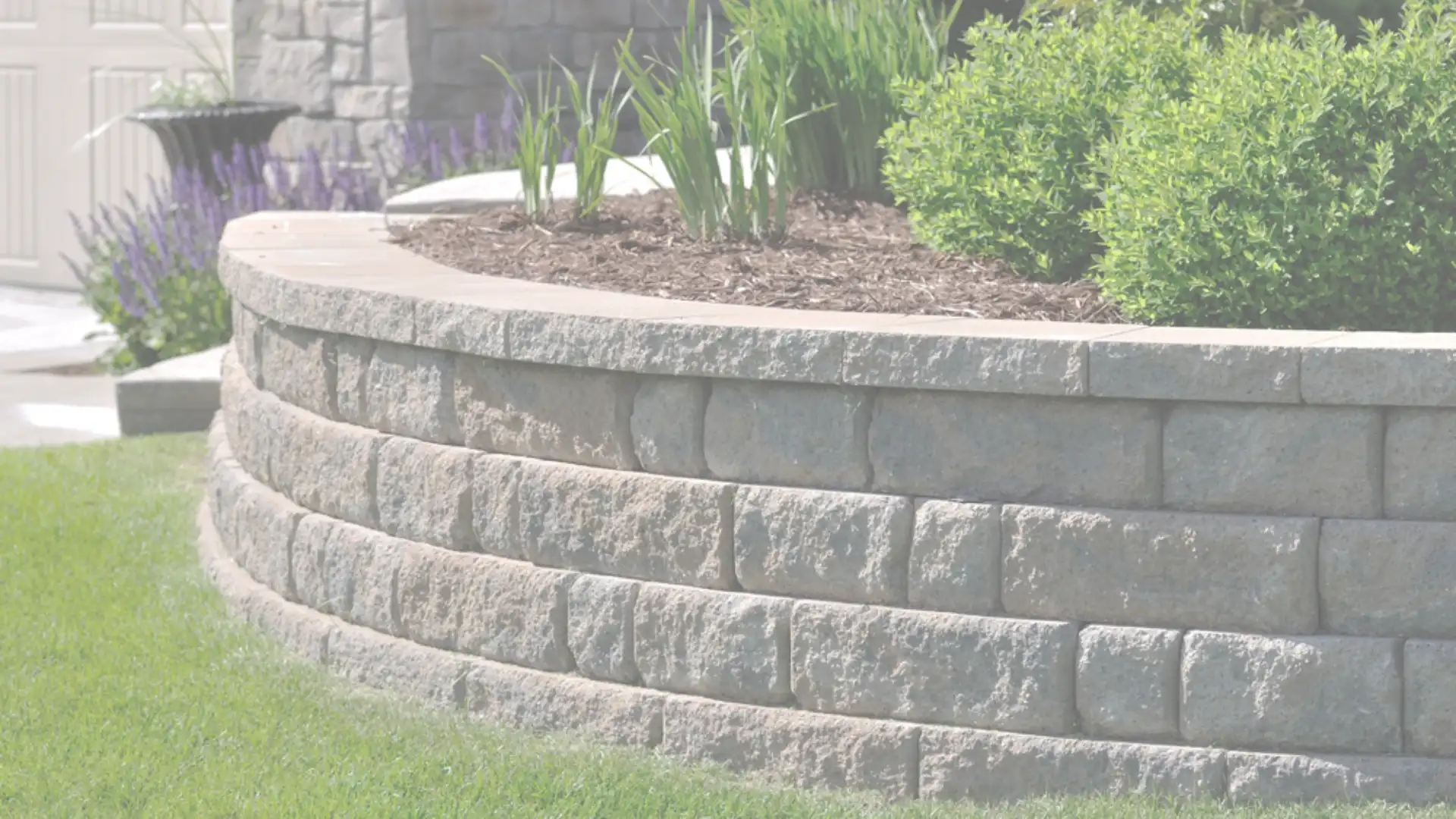 Curved block retaining wall in a Southern California garden built by expert contractors to enhance landscaping and prevent soil erosion.