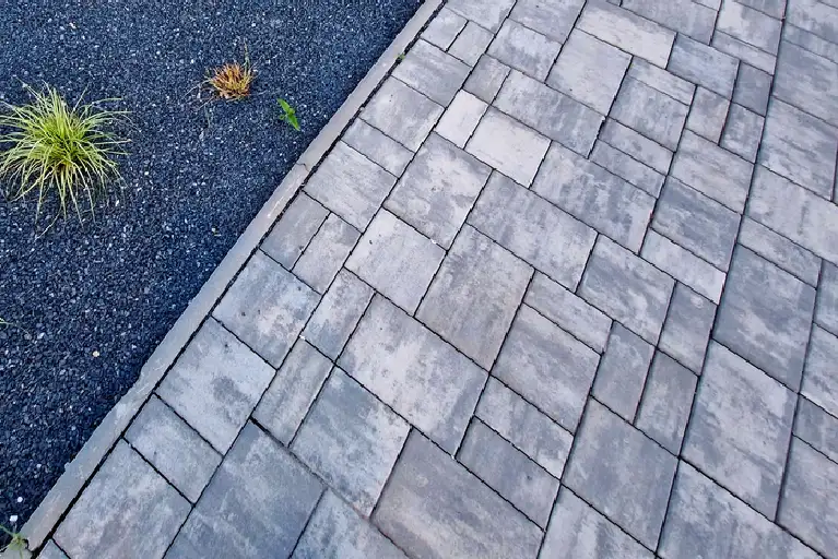 Textured paving stones and curved xeriscape landscaping design in a modern Fontana, California front yard