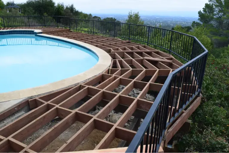 Framing stage of a custom poolside deck under construction in Southern California with hillside views and expert craftsmanship.