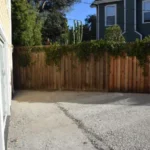 Excavated and graded backyard area prepared for artificial turf and porcelain paver installation at a Southern California property.