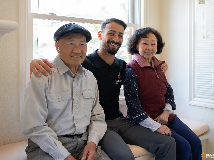 Smiling senior couple with Papaya Construction team member, showcasing trust, professionalism, and customer satisfaction after a successful home renovation.