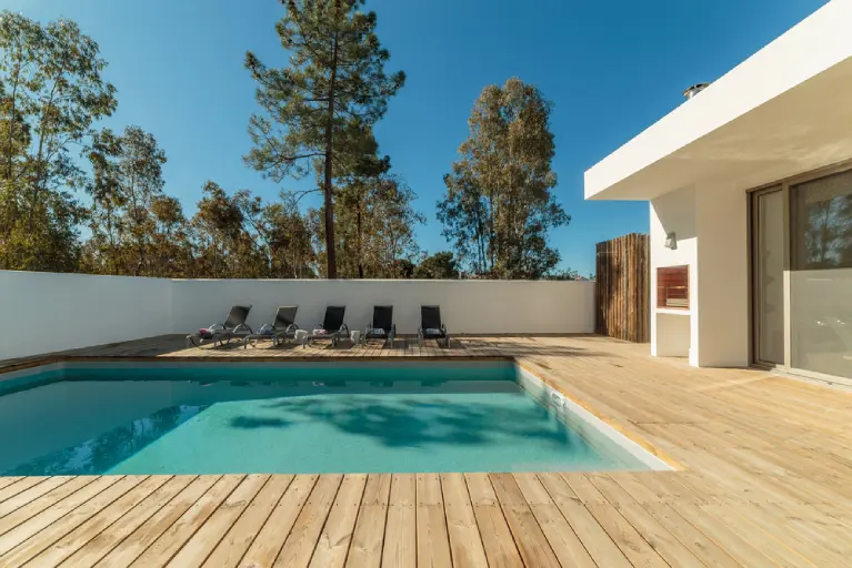 Modern poolside deck with wood flooring and lounge chairs—designed for comfort, style, and outdoor living in Southern California.