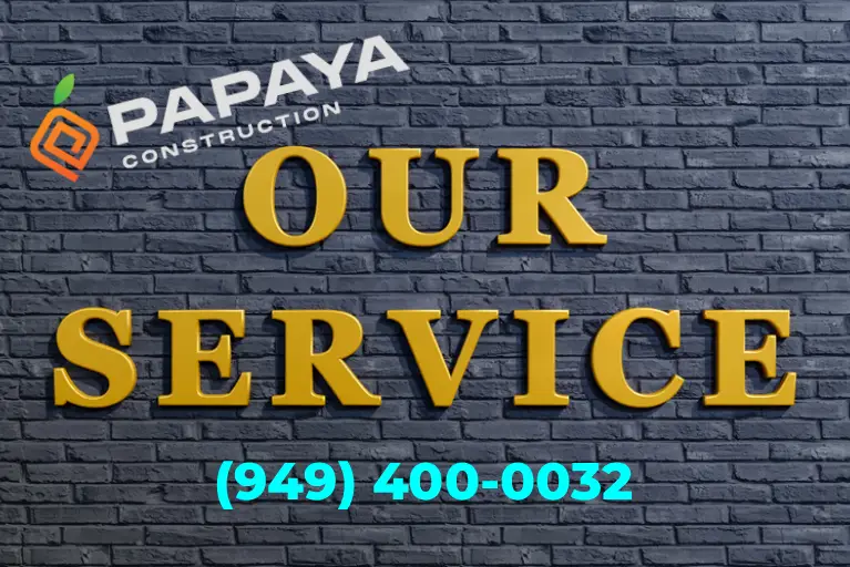 Papaya Construction sign on a brick wall displaying “Our Service” with contact number, representing comprehensive exterior services in Southern California.