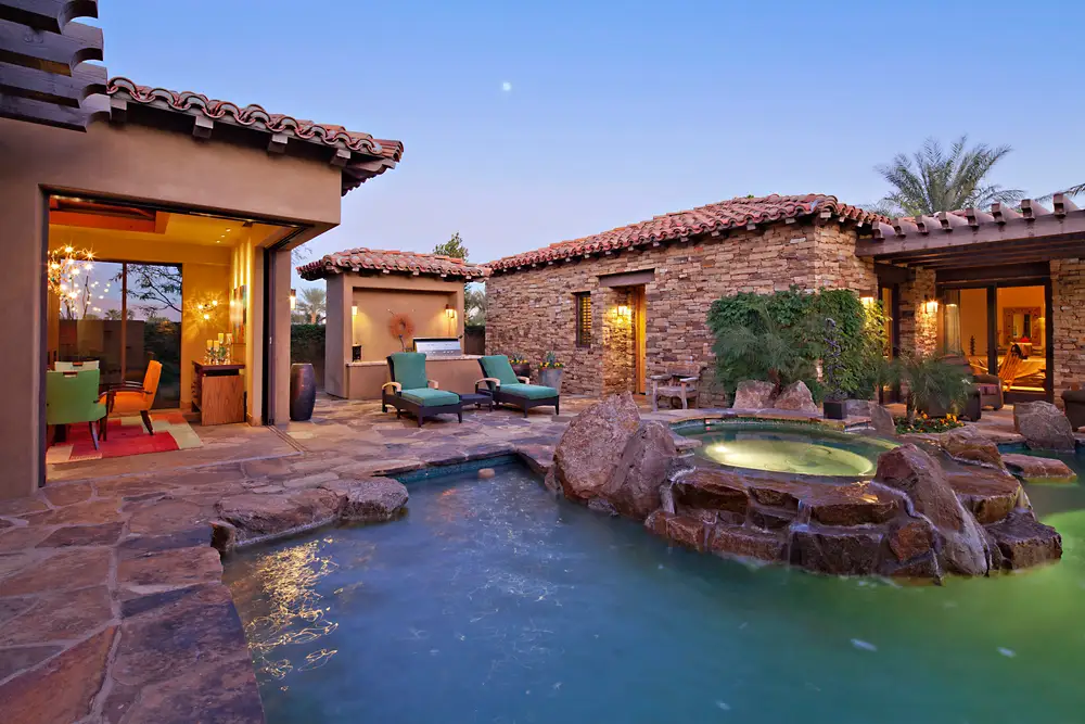 Southwestern-style backyard with stone spa, natural pool, and rustic patio design perfect for Southern California outdoor living