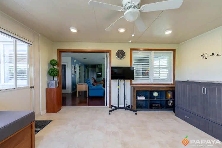 Interior view of a patio enclosure looking back into the main house, showing the seamless cased opening and transition to the living room.