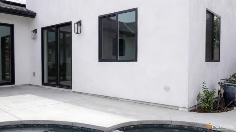 black framed windows installed into smooth white stucco exterior after renovation in Garden Grove CA