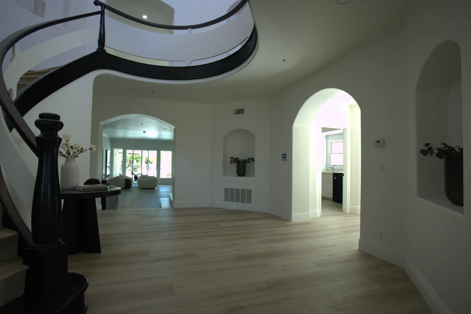 Curved balcony, arched openings and wide plank flooring in complete Laguna Hills home remodel
