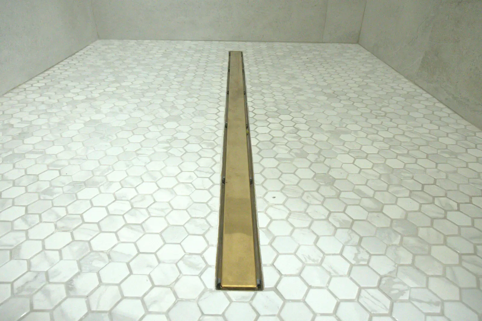 Hex mosaic shower floor with brass linear drain, Laguna Hills bathroom renovation detail